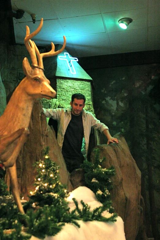 a young man walking between two deer statues