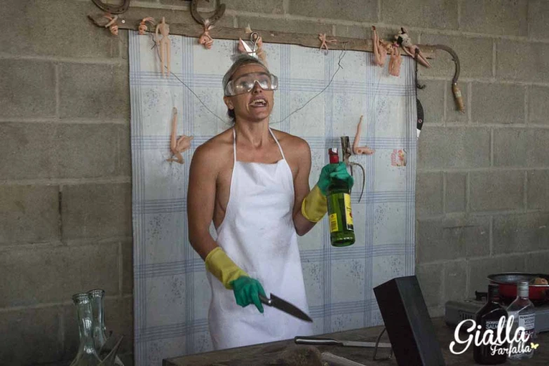 a woman is wearing goggles and holding a bottle of paint