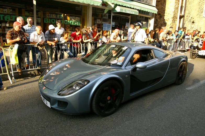 a grey sports car with no top on