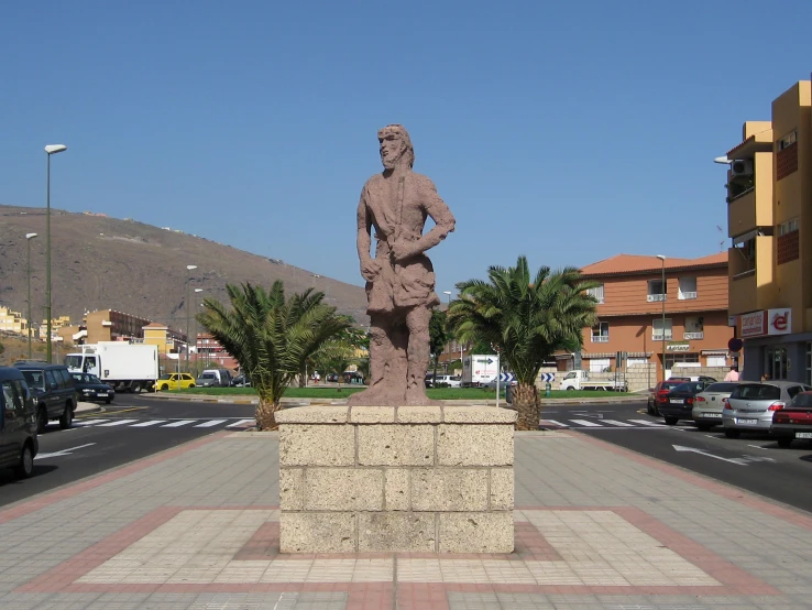 a statue of a man is near many parked cars