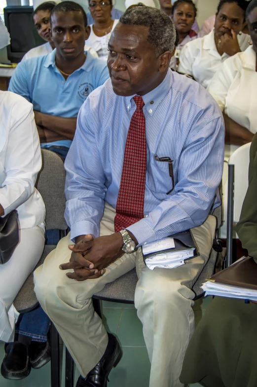 people are sitting down listening intently at the end of a meeting