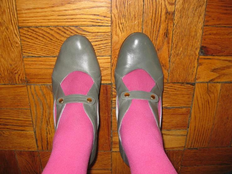 a person wearing grey shoes with pink socks