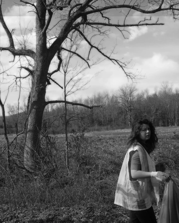 a woman is holding onto a 's purse as they walk away from the tree