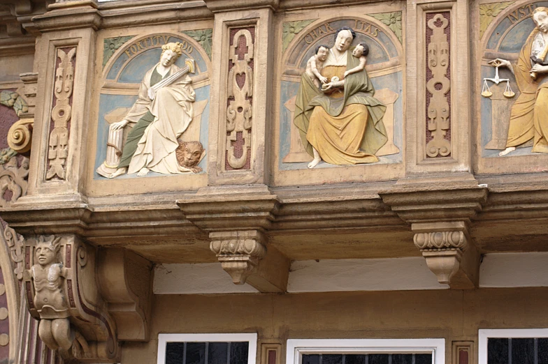 a balcony railing with statues of ladies and men