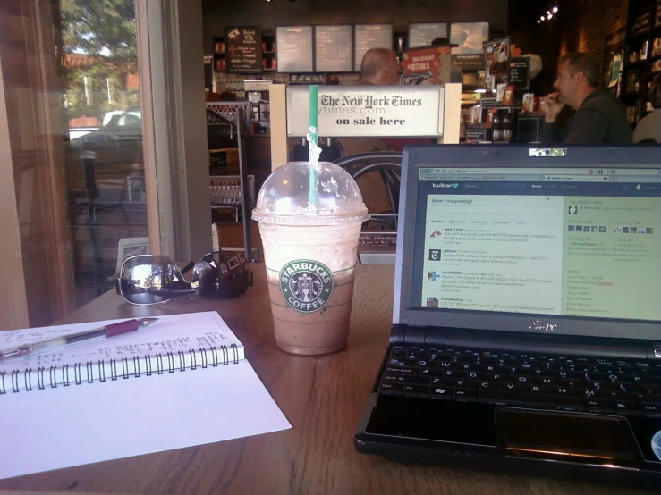 a coffee cup sitting next to a laptop computer on a desk