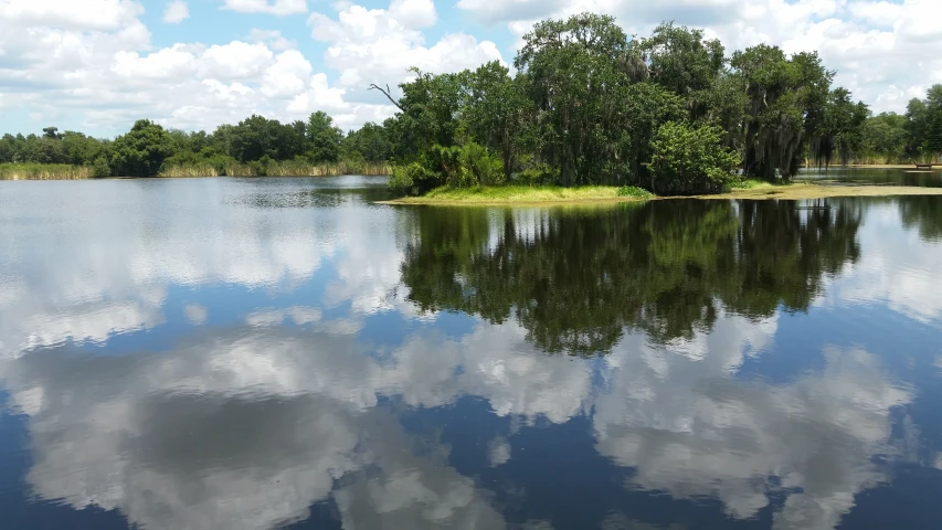 a lake that is reflecting the sky and clouds