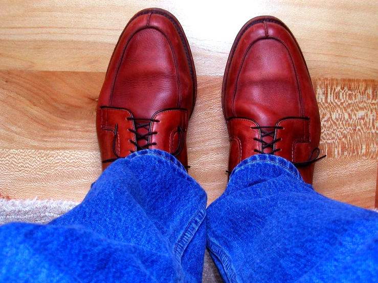 a pair of jeans, red shoes, and blue pants on the floor