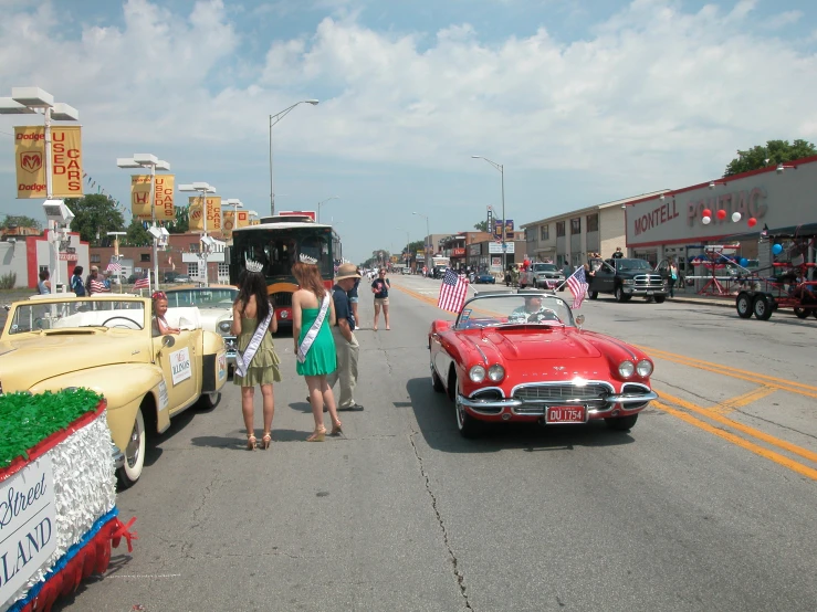 a car driving down a street near a person standing next to it