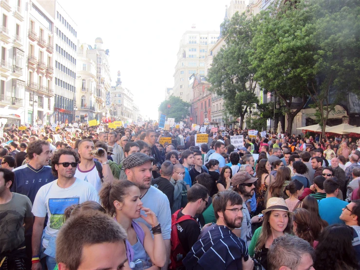 a large group of people standing around a city street