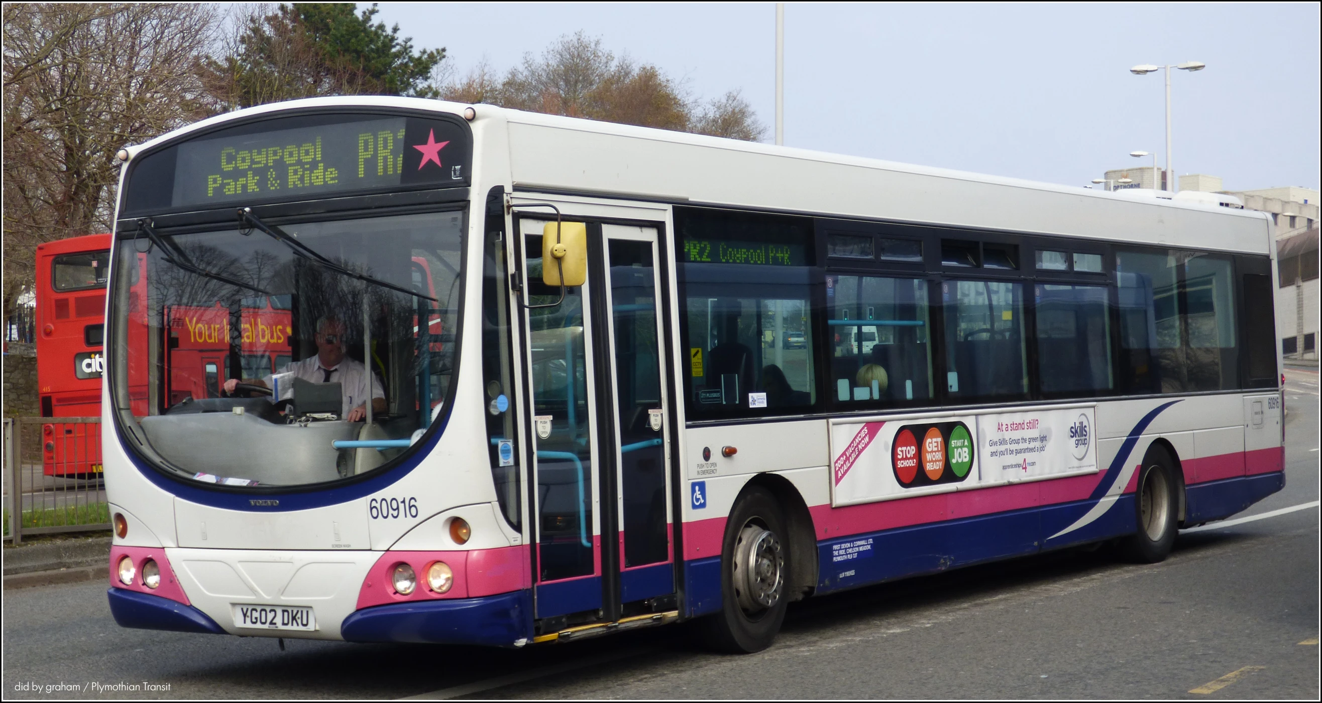 the city bus has pink and white trim on it