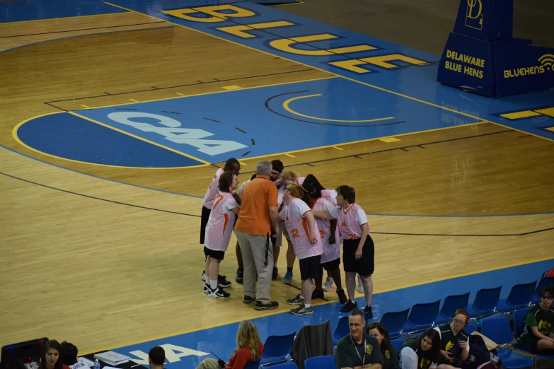 a group of women's basketball players standing around on the court