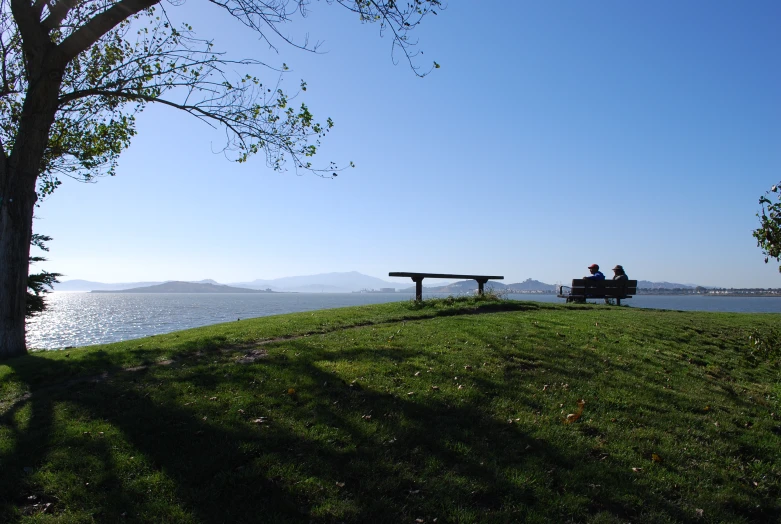 a couple of benches overlooking a river on a hill