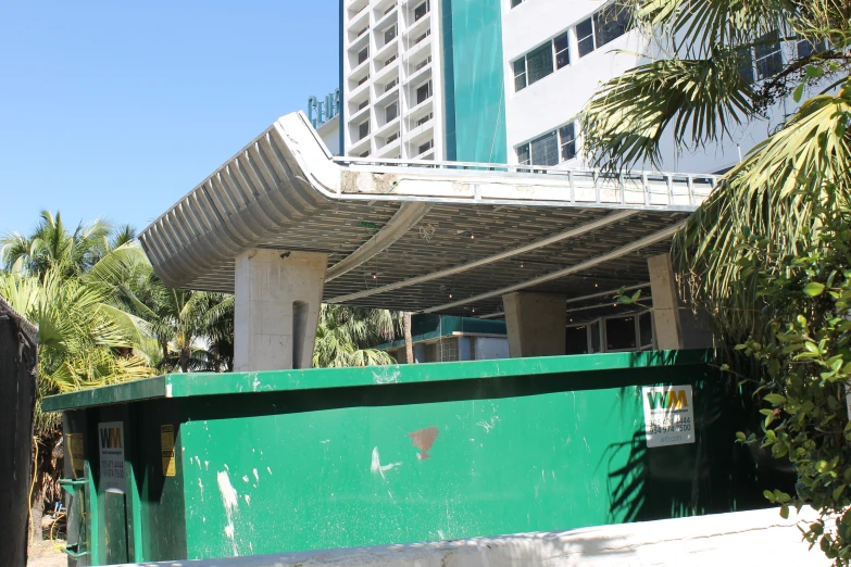 a large green building in front of a white and gray building