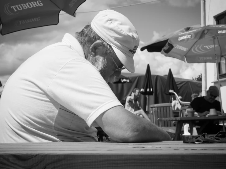 a man that is sitting down near umbrellas