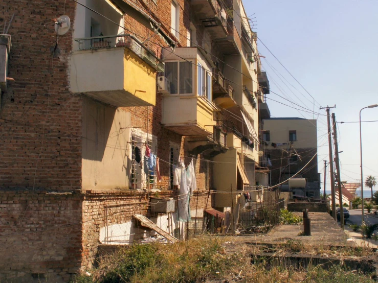 the building has many windows, balconies and washing lines