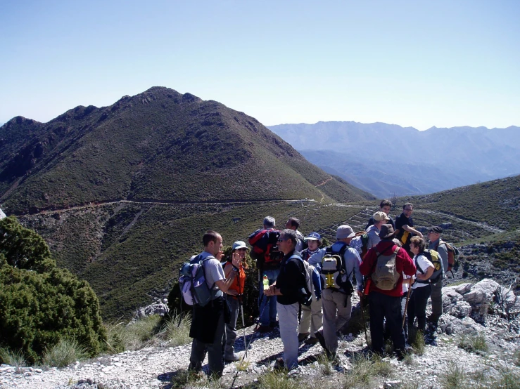 a group of people with backpacks standing in the mountains