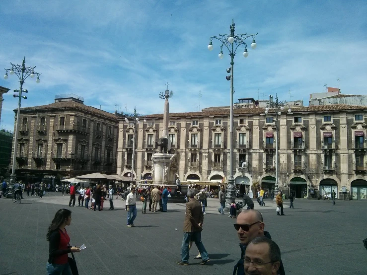 large group of people outside in front of buildings