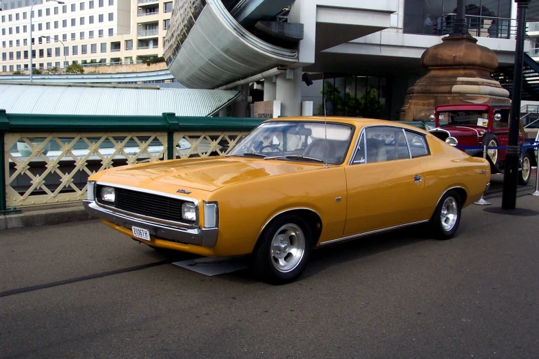 a yellow vintage car parked by some buildings