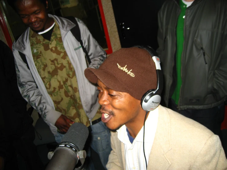 a man wearing headphones and a hat on top of a mic