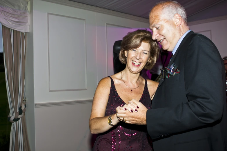 an older couple smiling while they dance together