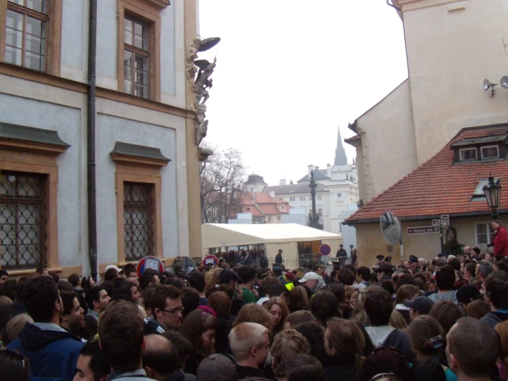 a large crowd of people are outside of buildings