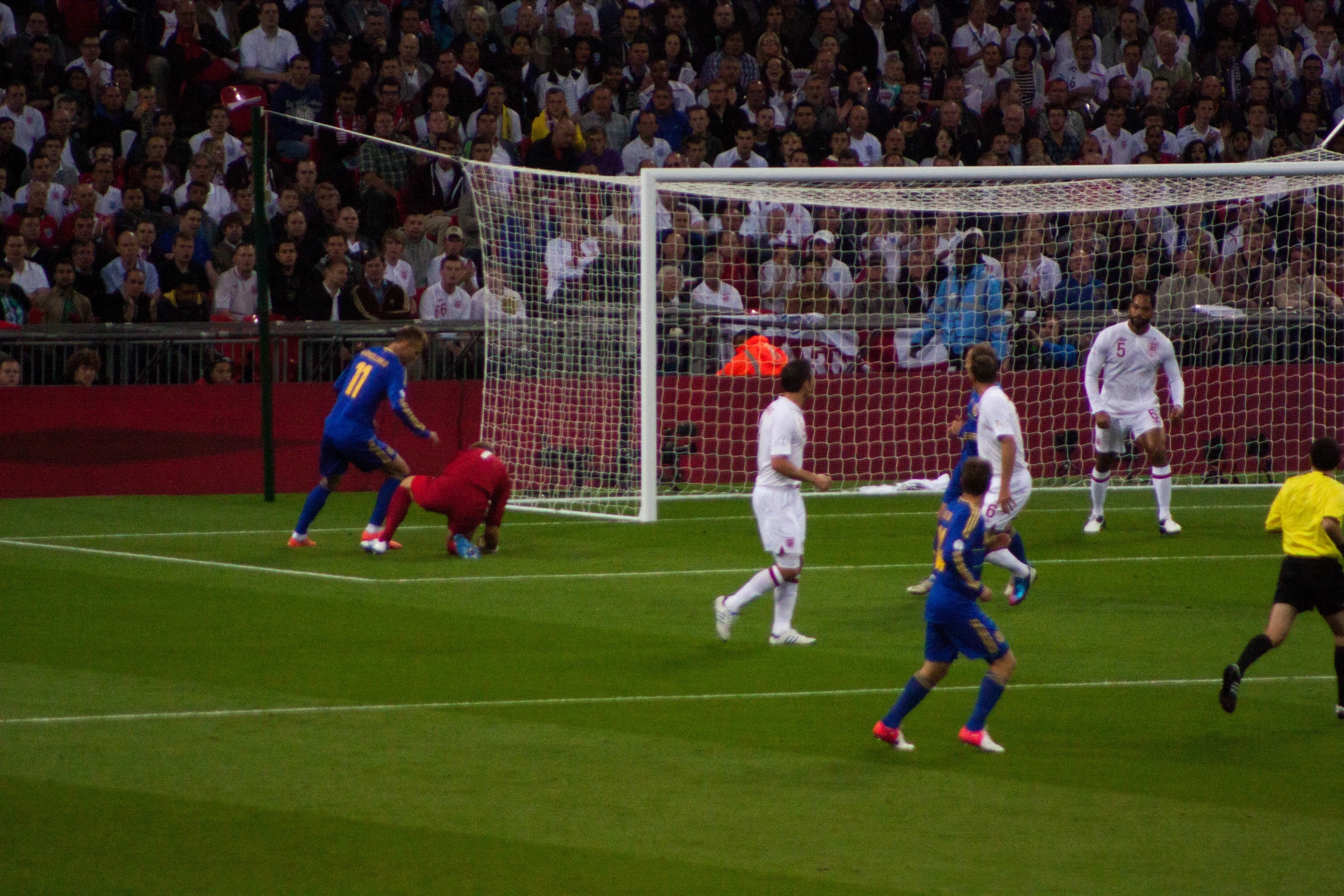 a group of soccer players and referee during a game