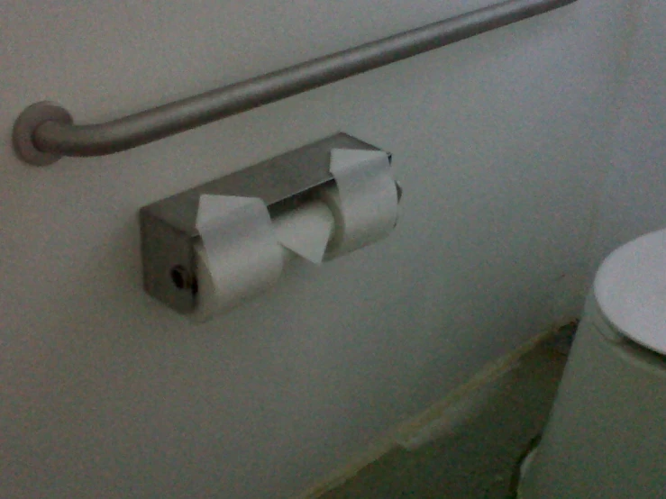 a roll of toilet paper on the wall above a toilet