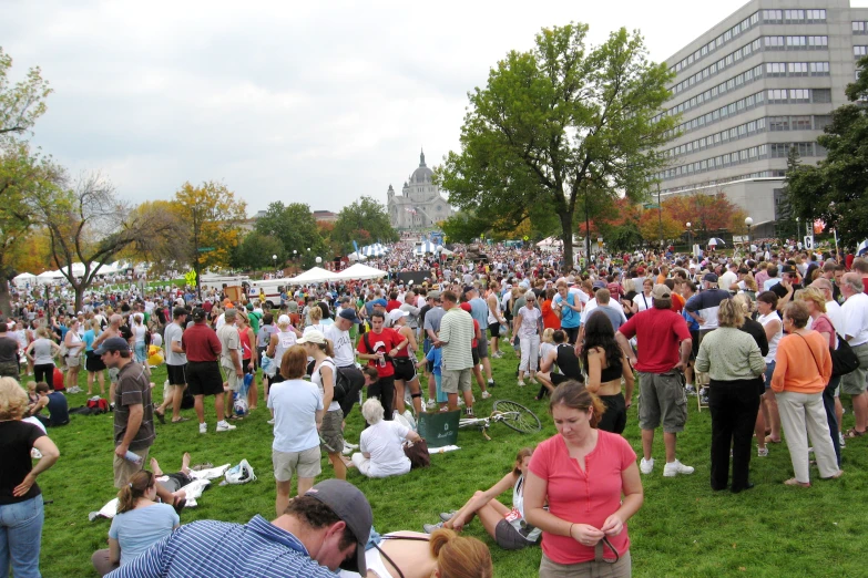 large groups of people standing in a park during the day