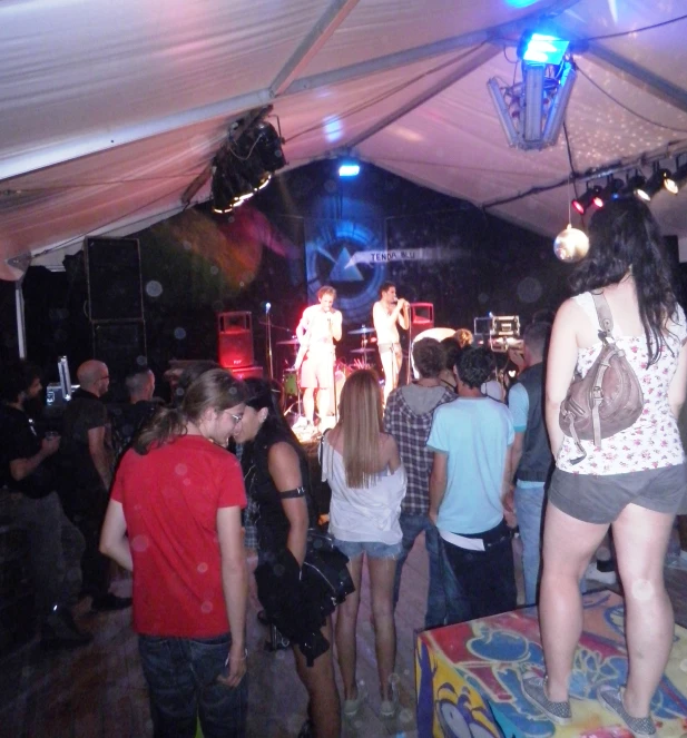 a group of people standing under a tent at a concert