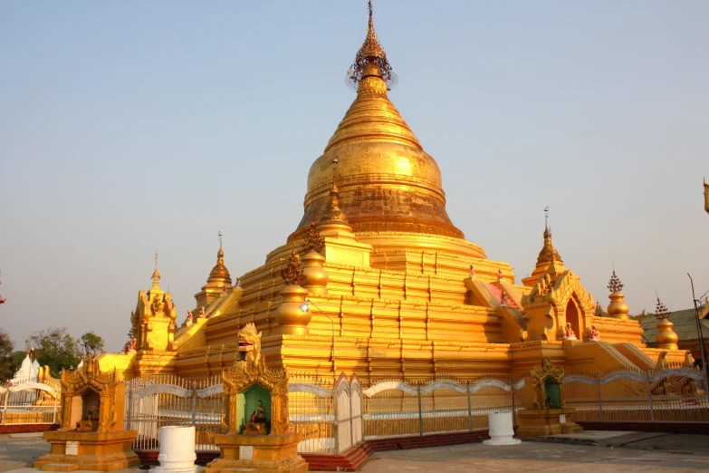 a yellow pagoda with golden domes and gates