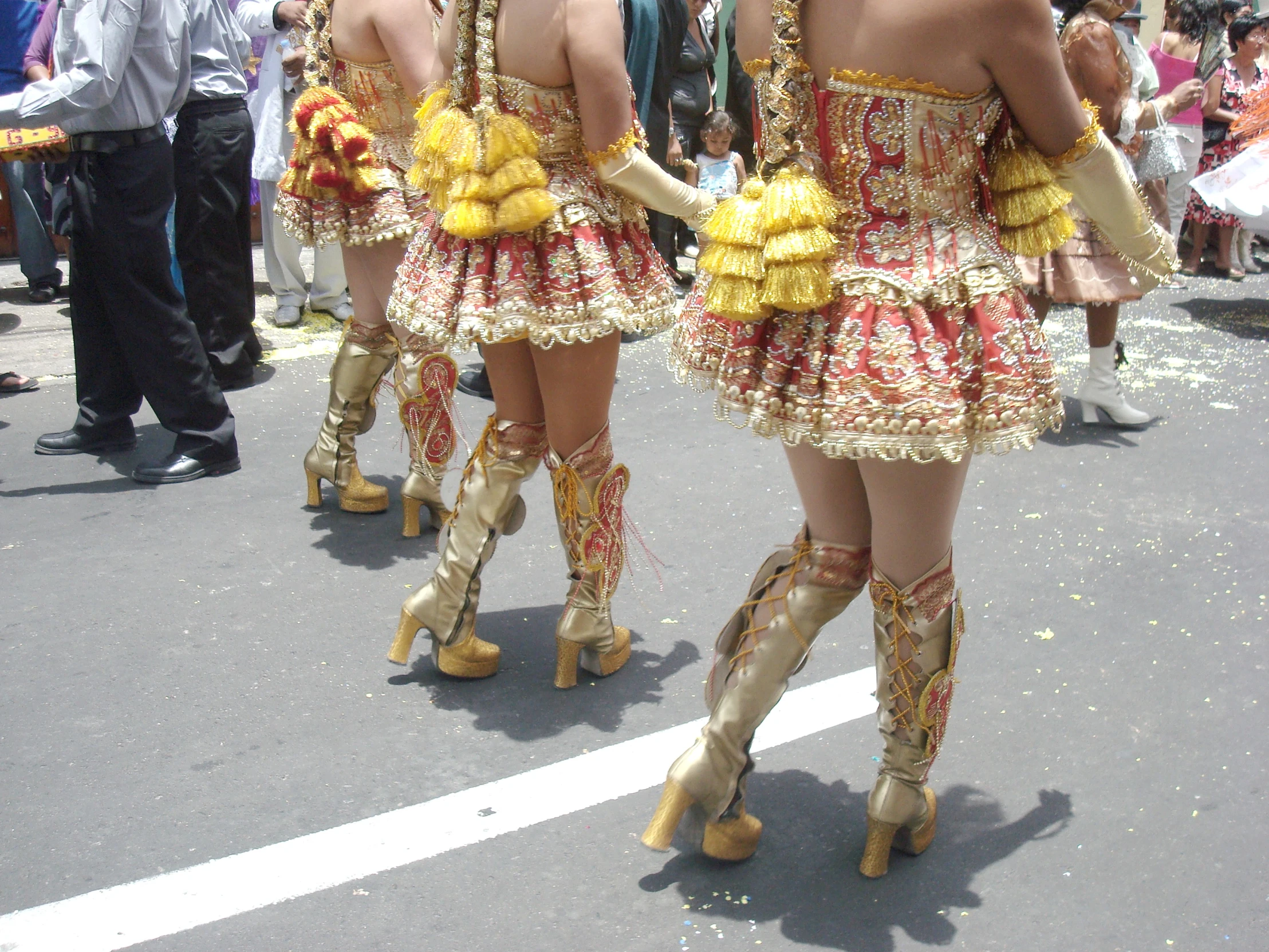 a group of women dressed in fancy attire marching down the street