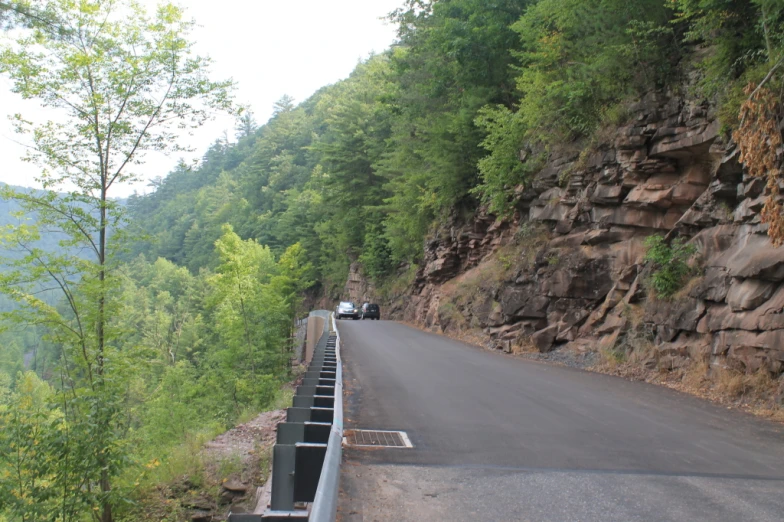 a truck on the side of a road near a mountain