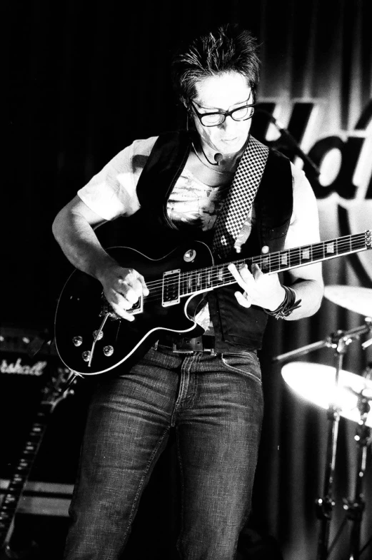 a man in glasses playing an electric guitar