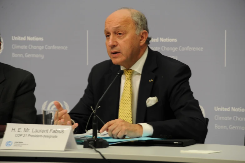 a man in business attire is sitting at a table