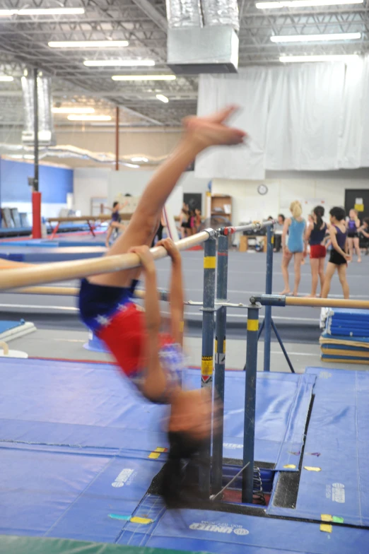 a boy on the floor doing a back - flip on the pole