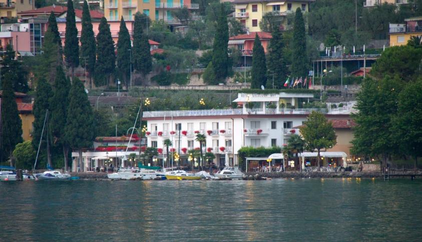 the boat is docked in front of the building near the water