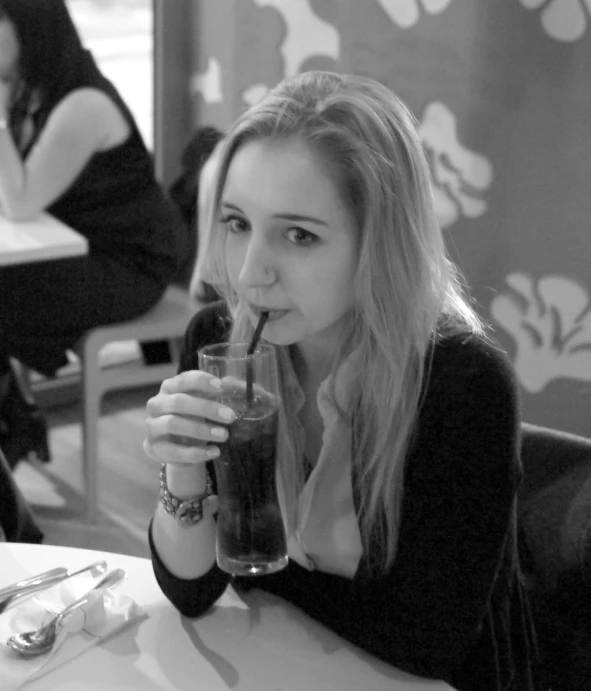 black and white po of a beautiful woman holding a drink