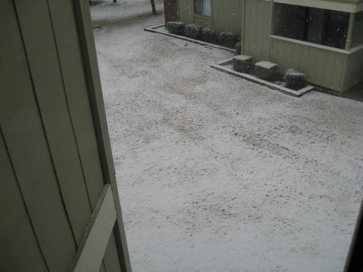 the inside door of a building is open to a snow covered yard