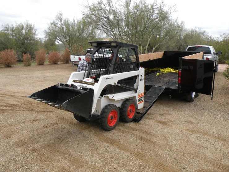 a small bulldozer is being loaded with items in the back