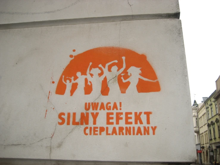 an orange and white sign with a sticker on it