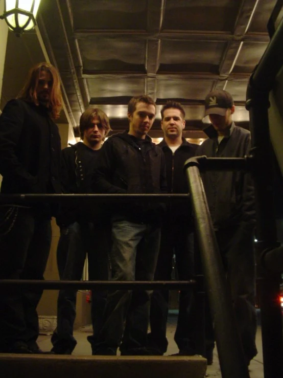 a group of men standing next to each other on stairs