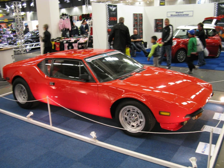 a large red car is on display at an auto show