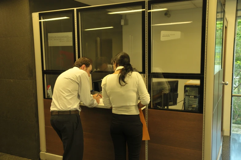 two people who are standing at a counter