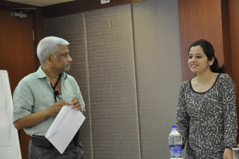 an old man and woman in a meeting room