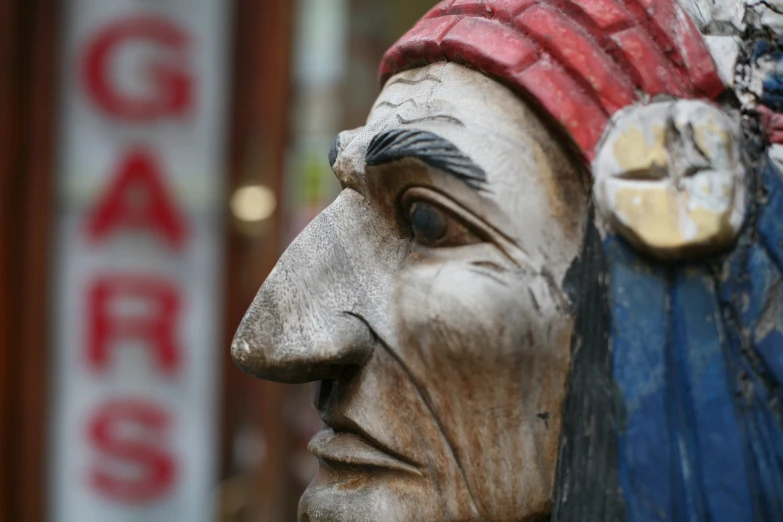 an old wooden statue with an odd hat on it's head