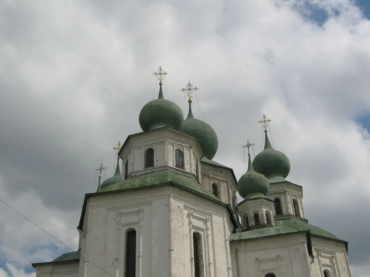 a very tall white building with green domes