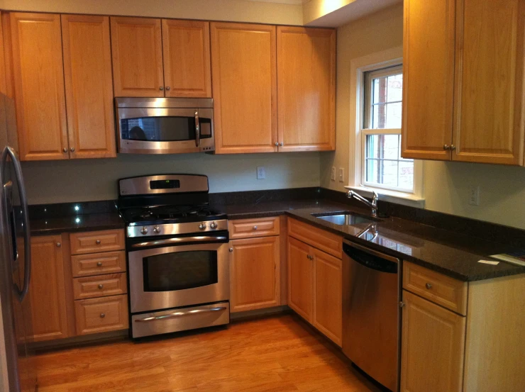 a kitchen with a counter, dishwasher and silver oven