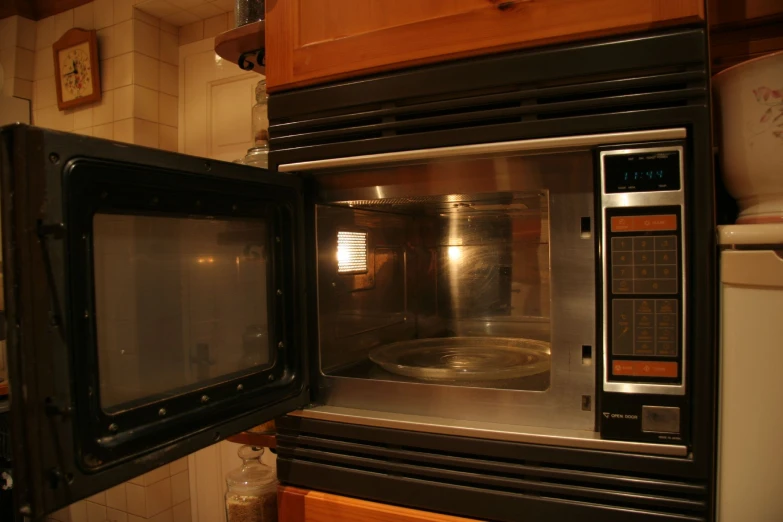 a black microwave oven with a pan cooking inside