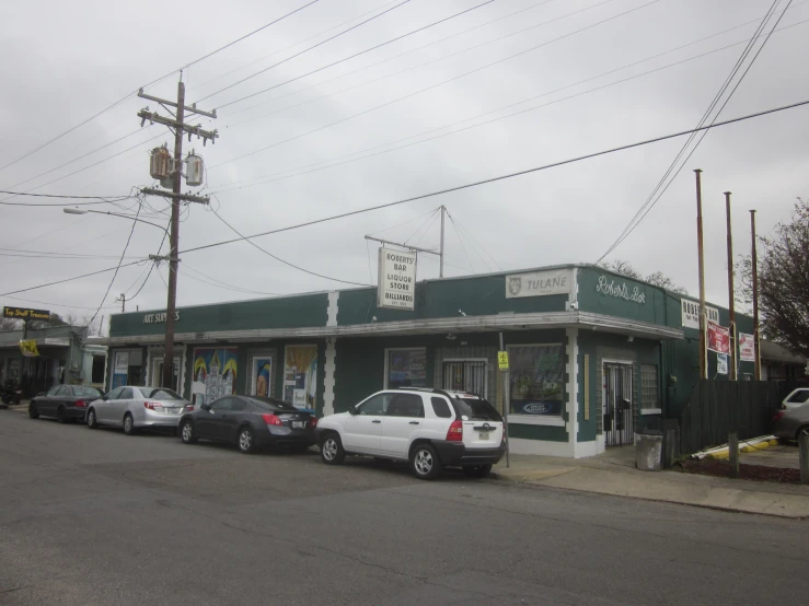 there are four cars parked in front of a store