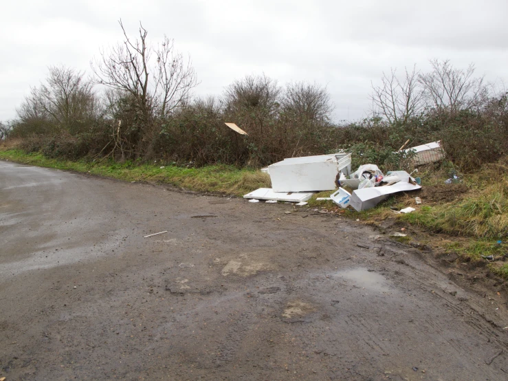 there is debris on the ground and a broken toilet